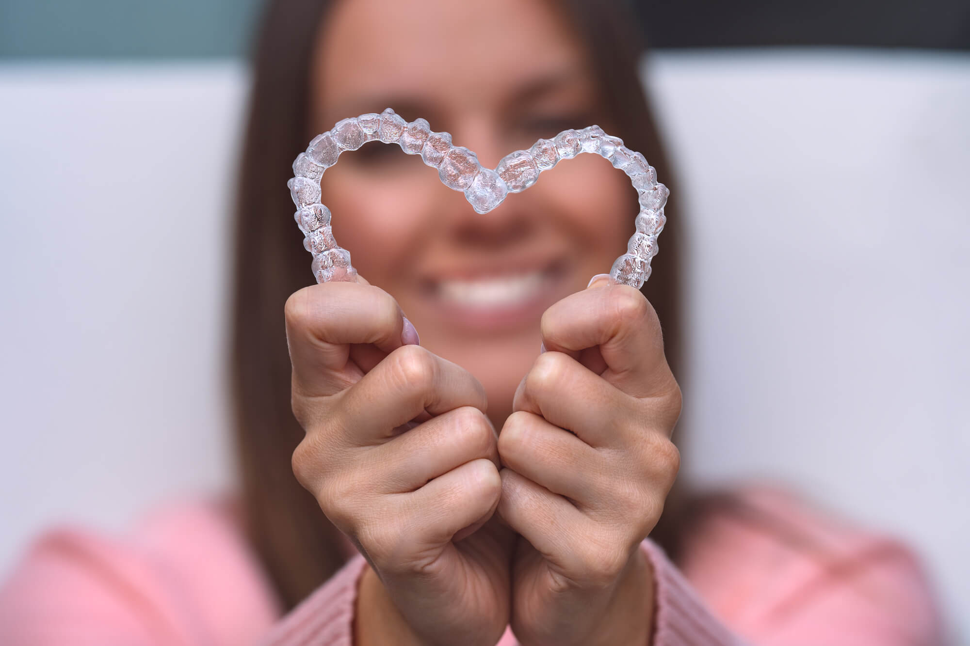 64db5355e1f692668d3c7c50 a dentist holding Invisalign aligners in Englewood